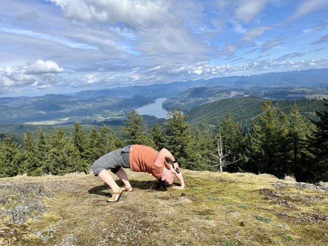 Woman in a back bend holding an handheld radio